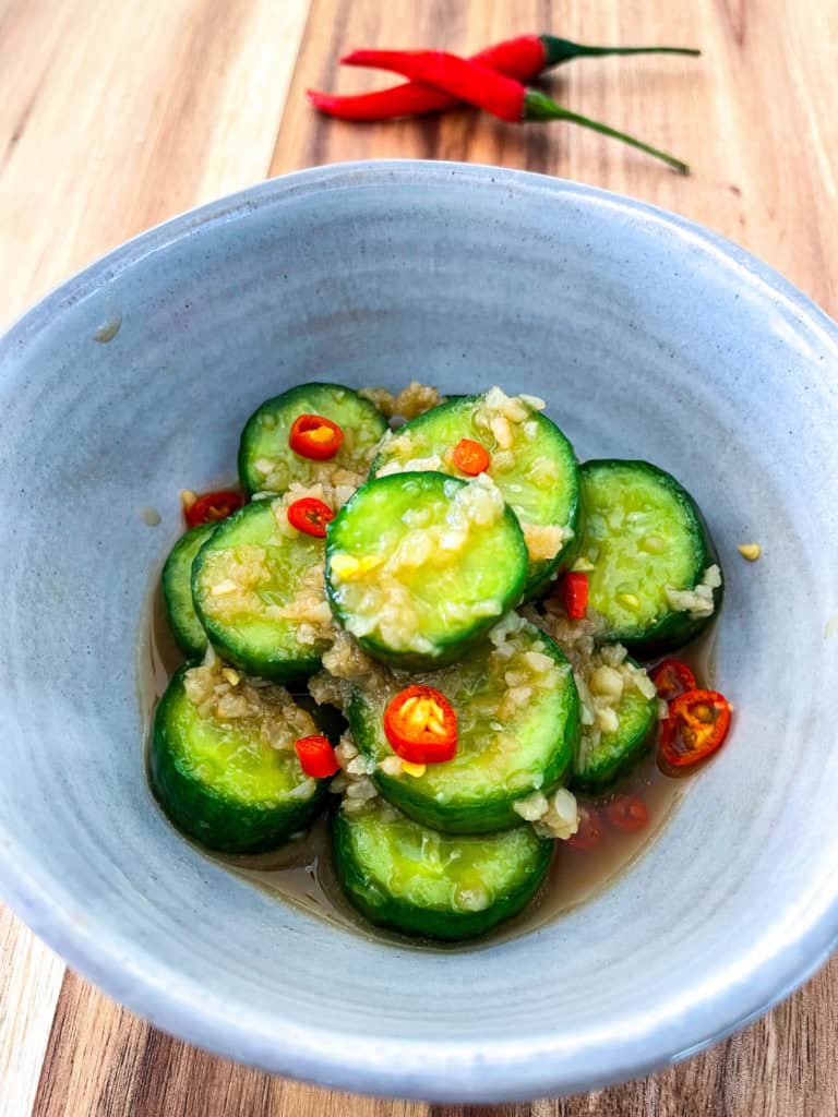 Taiwanese cucumber salad with garlic and sliced red chili in a blue bowl