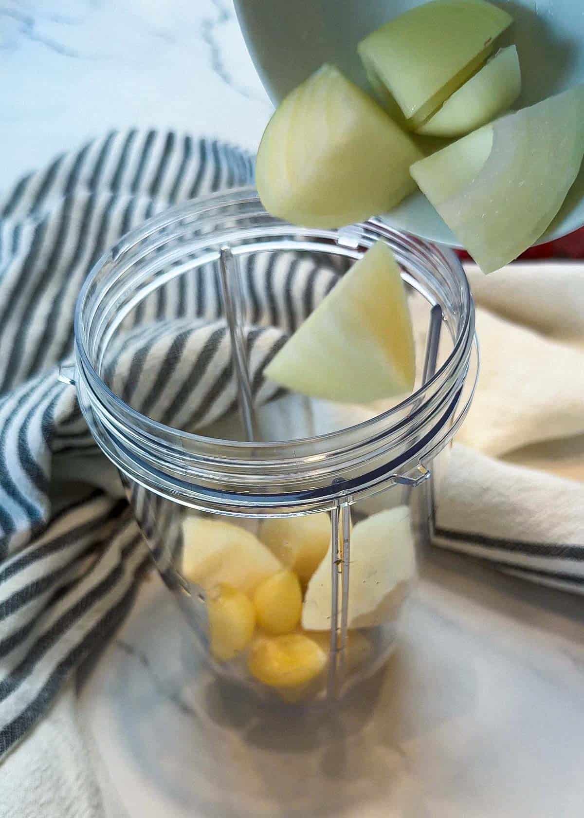 Pouring in ingredients to make boogie beef marinade in a blender cup with a decorative towel in the back.