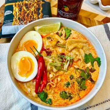 Creamy curry soup garnished with egg, Thai peppers and cilantro.