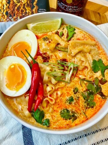 Creamy curry soup garnished with egg, Thai peppers and cilantro.