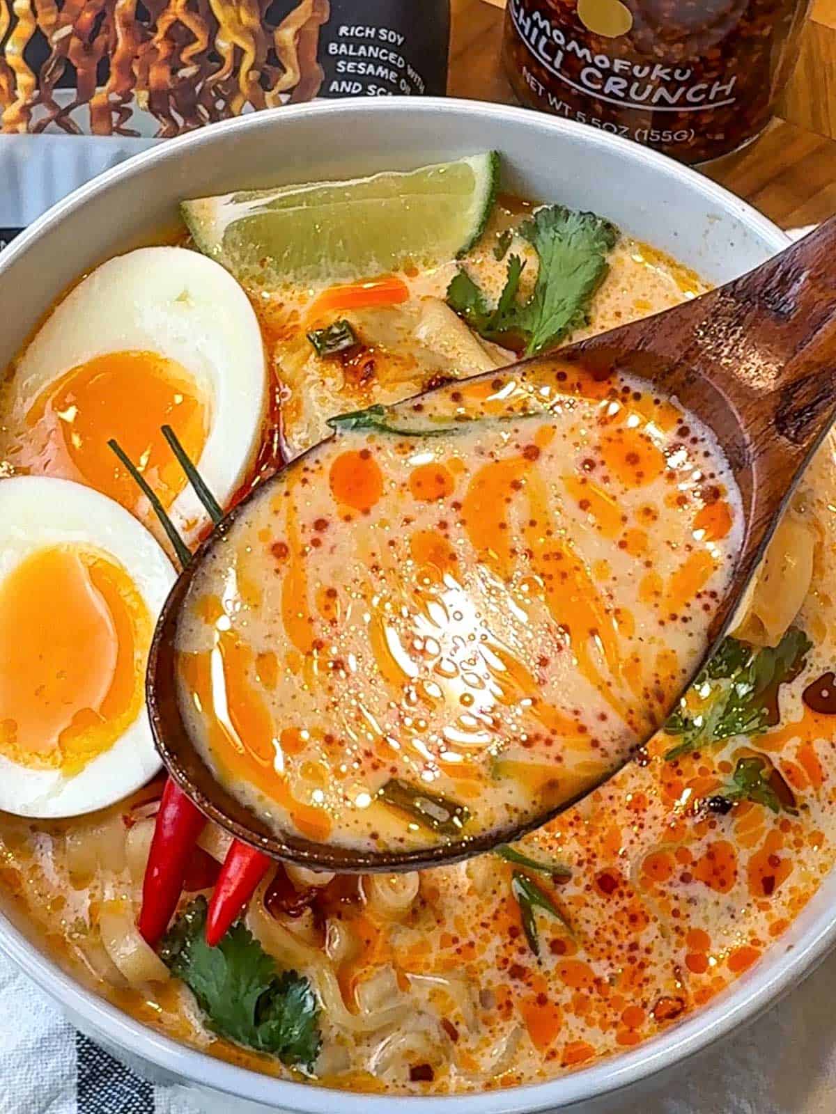 One pot curry noodle soup with dumplings, Momofuku noodles, green onions, and boiled egg in creamy coconut curry broth