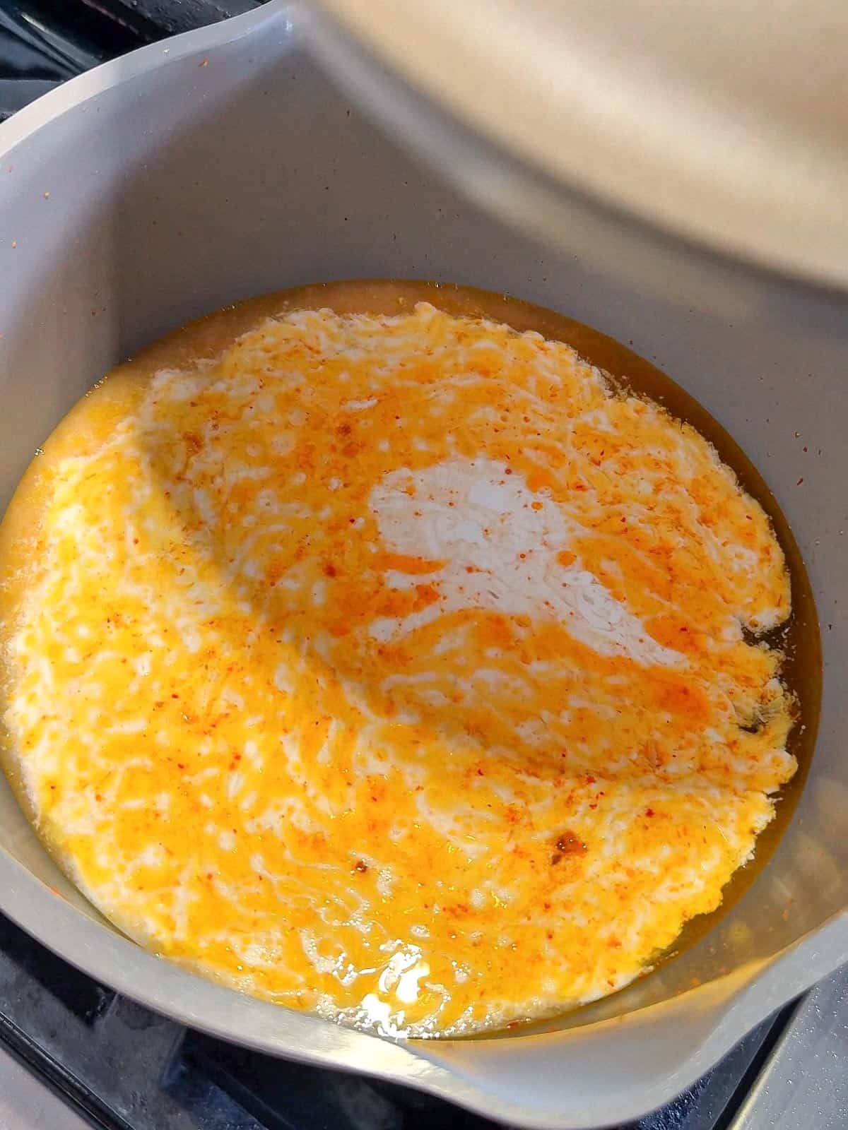 Momofuku noodles cooking in creamy coconut curry soup