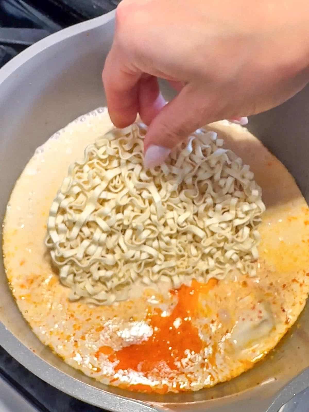 Momofuku noodles cooking in creamy coconut curry soup