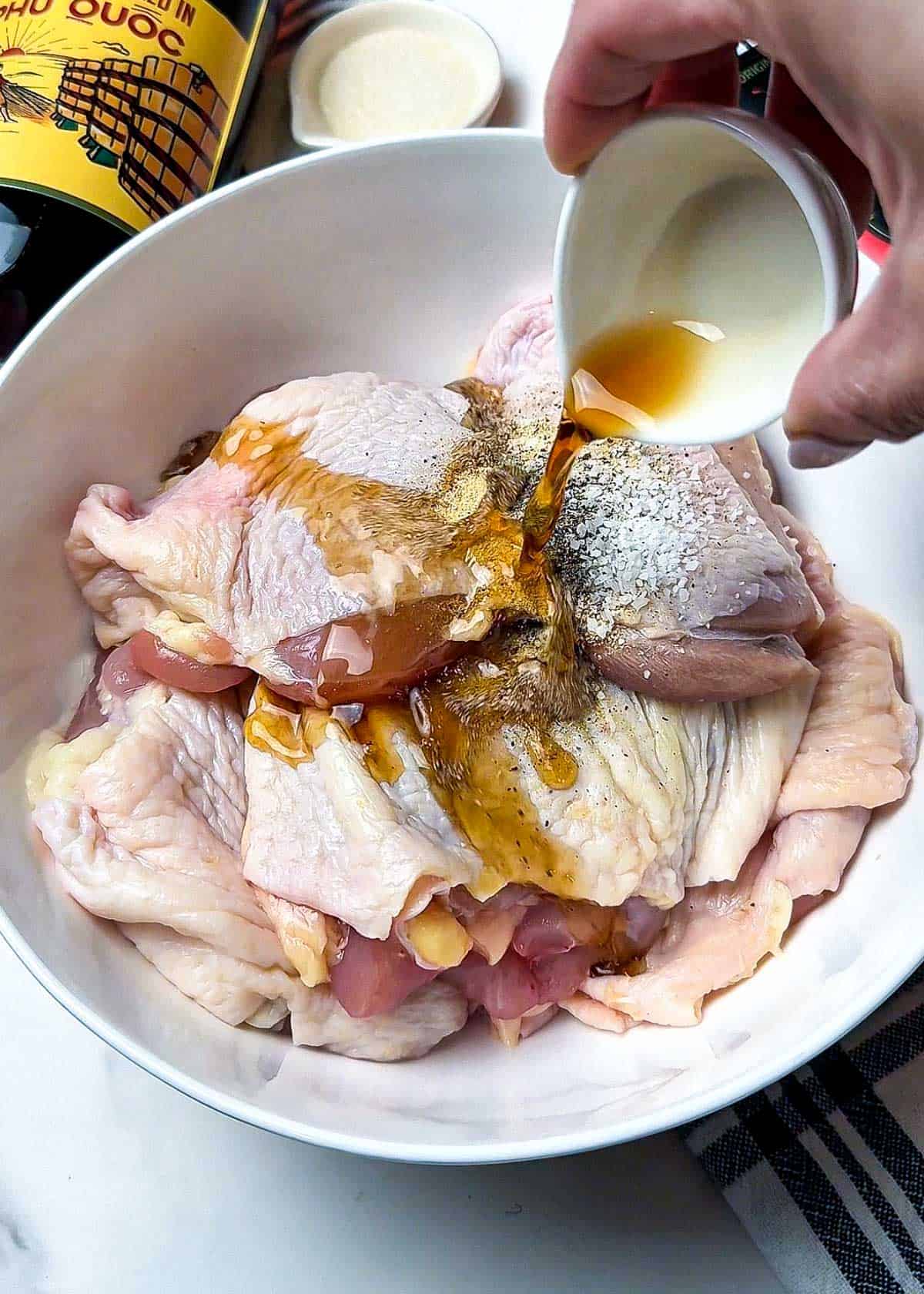 chicken thigh recipe marinade with fish sauce hot sauce and spices mixed with boneless chicken thighs