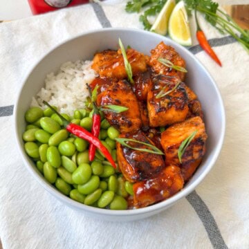 Golden Lava cubed Salmon in a white bowl with edamame