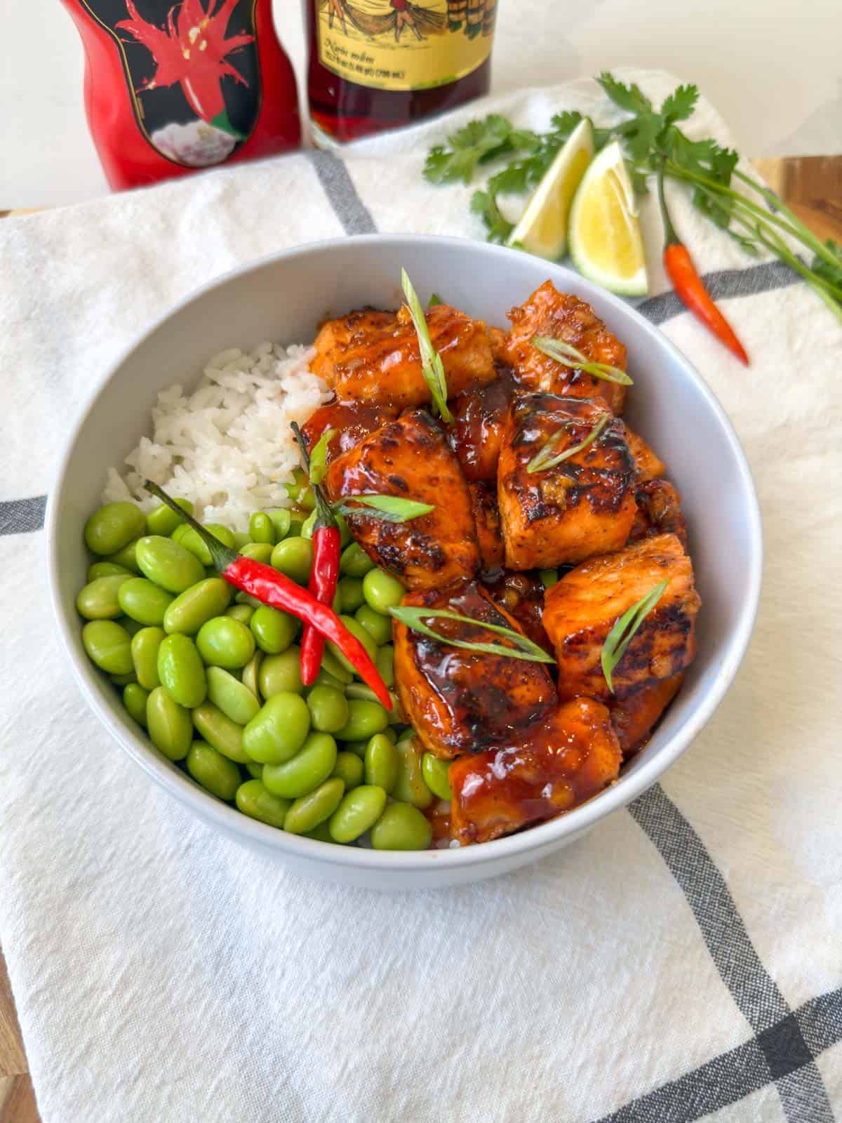 Golden Lava cubed Salmon in a white bowl with edamame