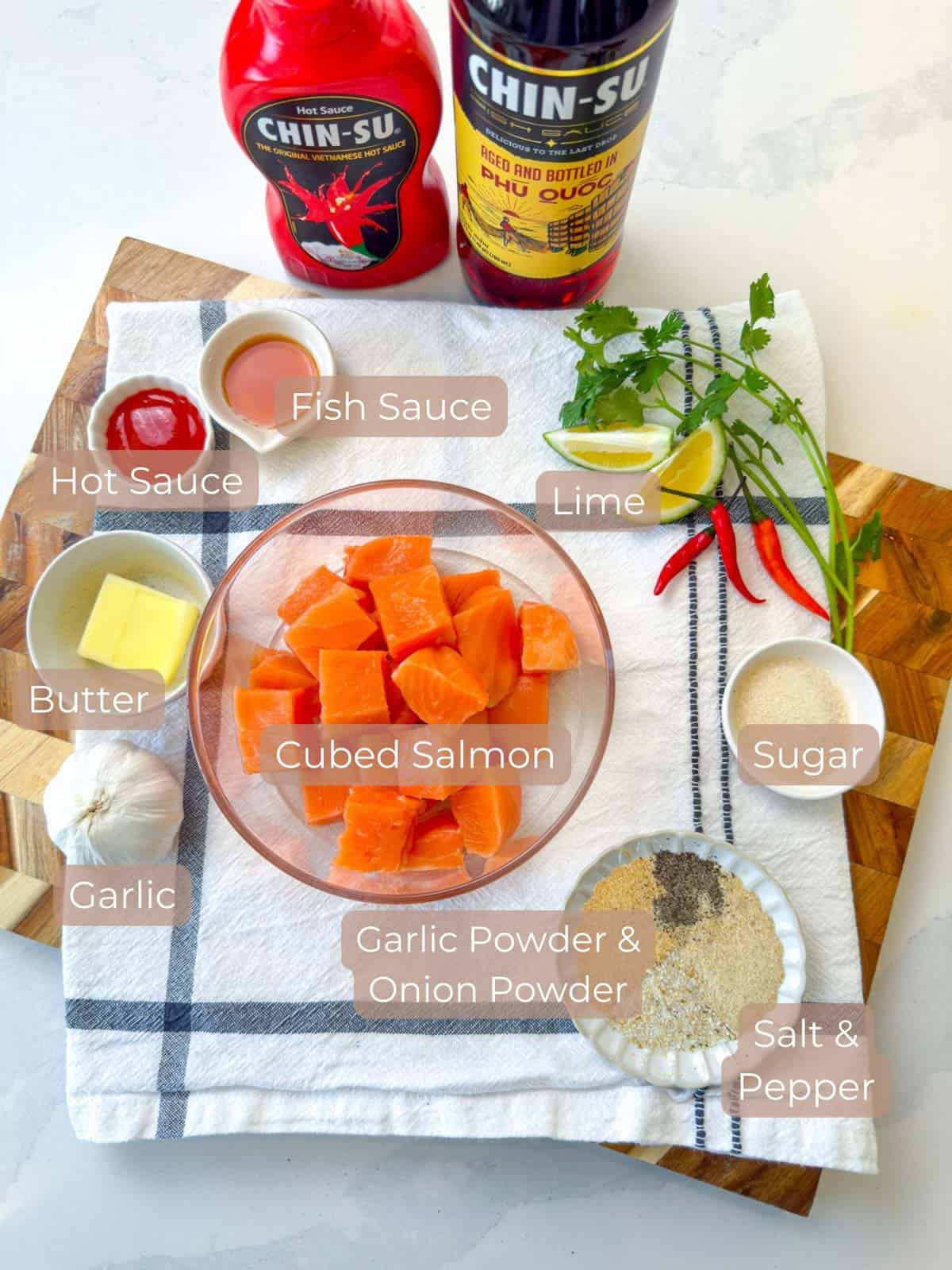 Various ingredients for salmon bowls plated and labeled such as salmon fish sauce butter garlic sugar