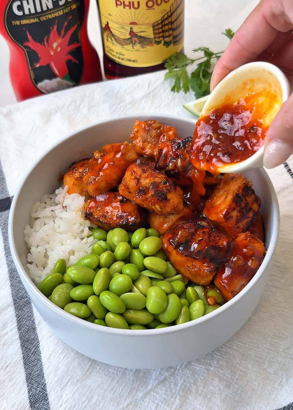 Pouring Golden lava a sticky sauce over salmon rice bowl