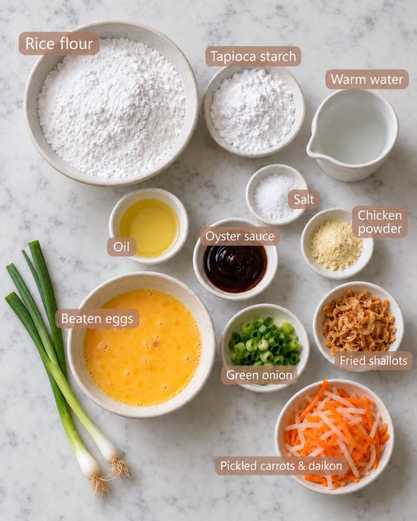 Ingredients for bánh bột chiên: rice flour, tapioca starch, warm water, salt, chicken powder, oil, oyster sauce, beaten eggs, green onions, fried shallots and pickled carrots and daikon